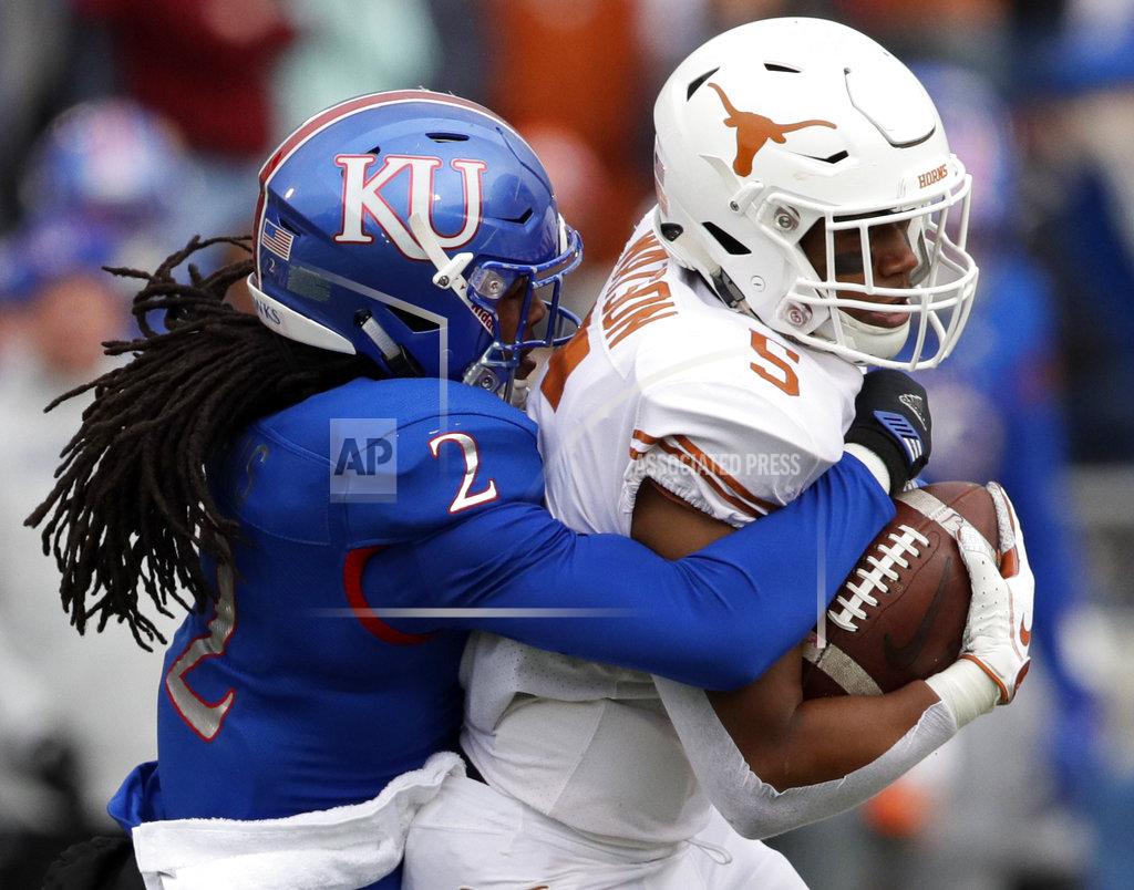 Orlin Wagner Texas running back Tre Watson (5) is tackled by Kansas cornerback Corione Harris (2) during the first half of an NCAA college football game in Lawrence, Kan., Friday, Nov. 23, 2018. (AP Photo/Orlin Wagner)