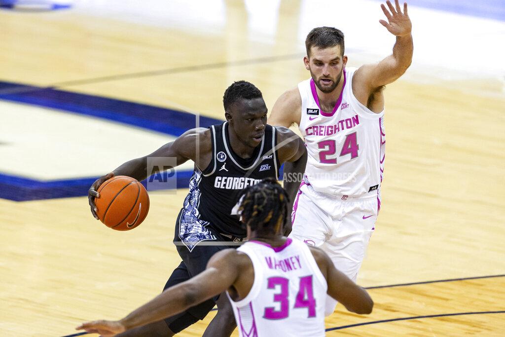 John Peterson Georgetown forward Chudier Bile (4) drives the basket against Creighton guard Mitch Ballock (24) and guard Denzel Mahoney (34) during the second half of an NCAA college basketball game Wednesday, Feb. 3, 2021, in Omaha, Neb. (AP Photo/John Peterson)