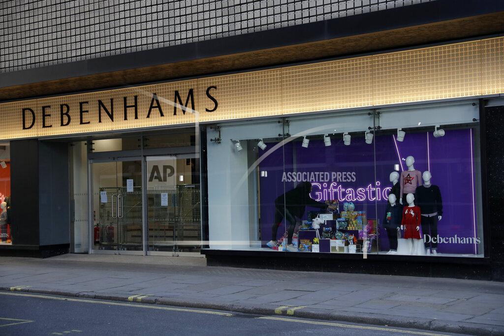 Matt Dunham A worker adjusts a window display at the Debenhams flagship department store on Oxford Street, in London, Tuesday, Dec. 1, 2020. In another dark day for the British retailing industry, Debenhams said Tuesday it will start liquidating its business after a potential buyer of the company pulled out, a move that looks like it will cost 12,000 workers their jobs. (AP Photo/Matt Dunham)