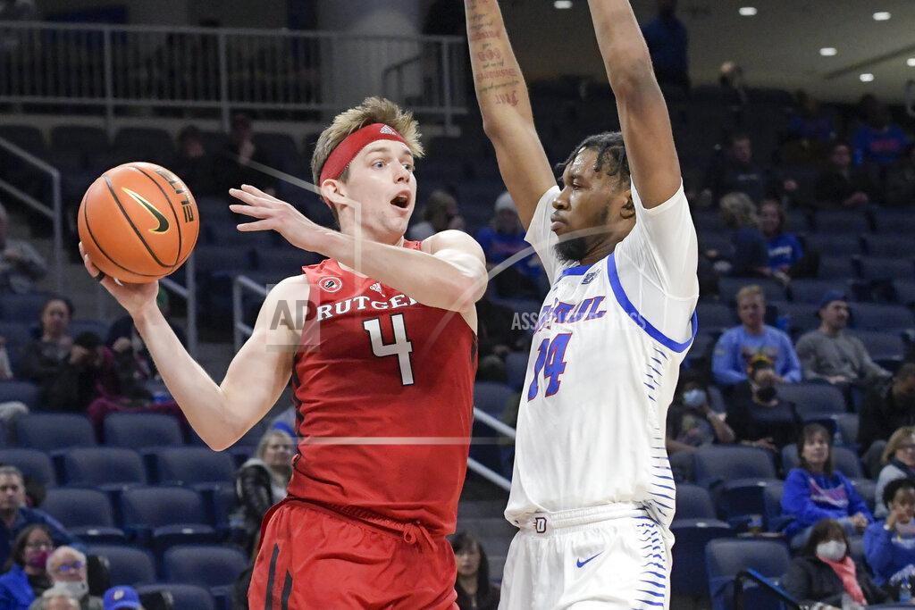 Mark Black Rutgers' Paul Mulcahy (4) passes to the outside around DePaul's Nick Ongenda (14) during the first half of an NCAA college basketball game Thursday, Nov. 18, 2021, in Chicago. (AP Photo/Mark Black)
