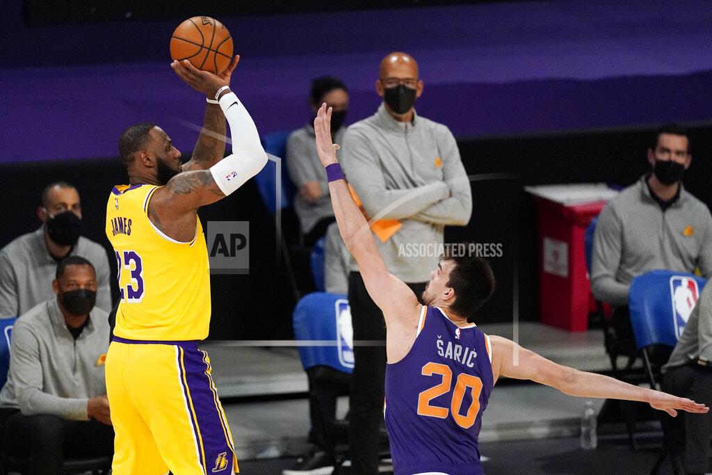 Mark J. Terrill Los Angeles Lakers forward LeBron James, left, shoots as Phoenix Suns forward Dario Saric defends during the first half of an NBA basketball game Tuesday, March 2, 2021, in Los Angeles. (AP Photo/Mark J. Terrill)