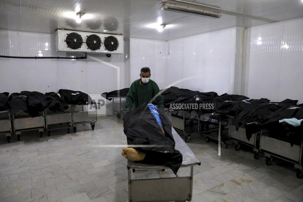 Ebrahim Noroozi A cemetery worker prepares the body of a man who died from COVID-19, in a morgue at the Behesht-e-Zahra cemetery on the outskirts of the Iranian capital, Tehran, Iran, Sunday, Nov. 1, 2020. Mortuary attendants prepare each body for the ritual washing required for the Muslim dead. During the pandemic, that now includes the use of disinfectants. (AP Photo/Ebrahim Noroozi)