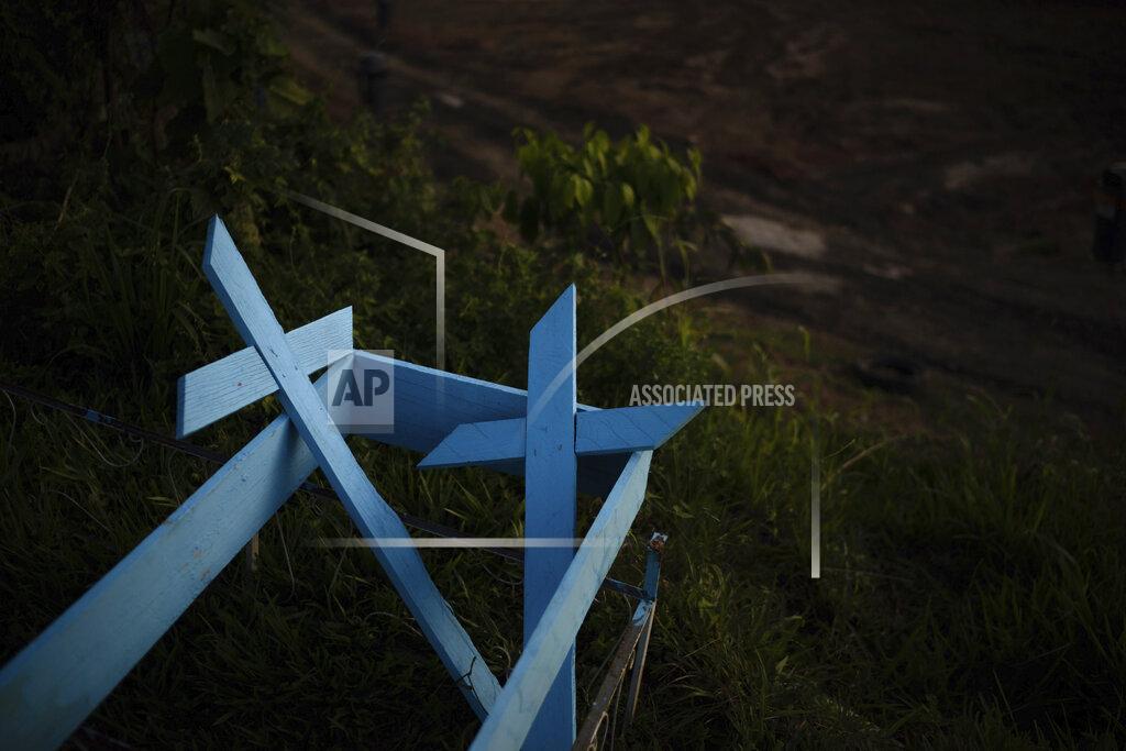 Felipe Dana FILE - In this May 16, 2020, file photo, painted wooden crosses lie on the roadside of a new section of the Nossa Senhora Aparecida cemetery in Manaus, Brazil. Even amid a global pandemic, there’s no sign that corruption is slowing down in Latin America. In Brazil, which has the world's second-highest number of confirmed cases, police created a task force to investigate crimes tied to the pandemic. (AP Photo/Felipe Dana, File)