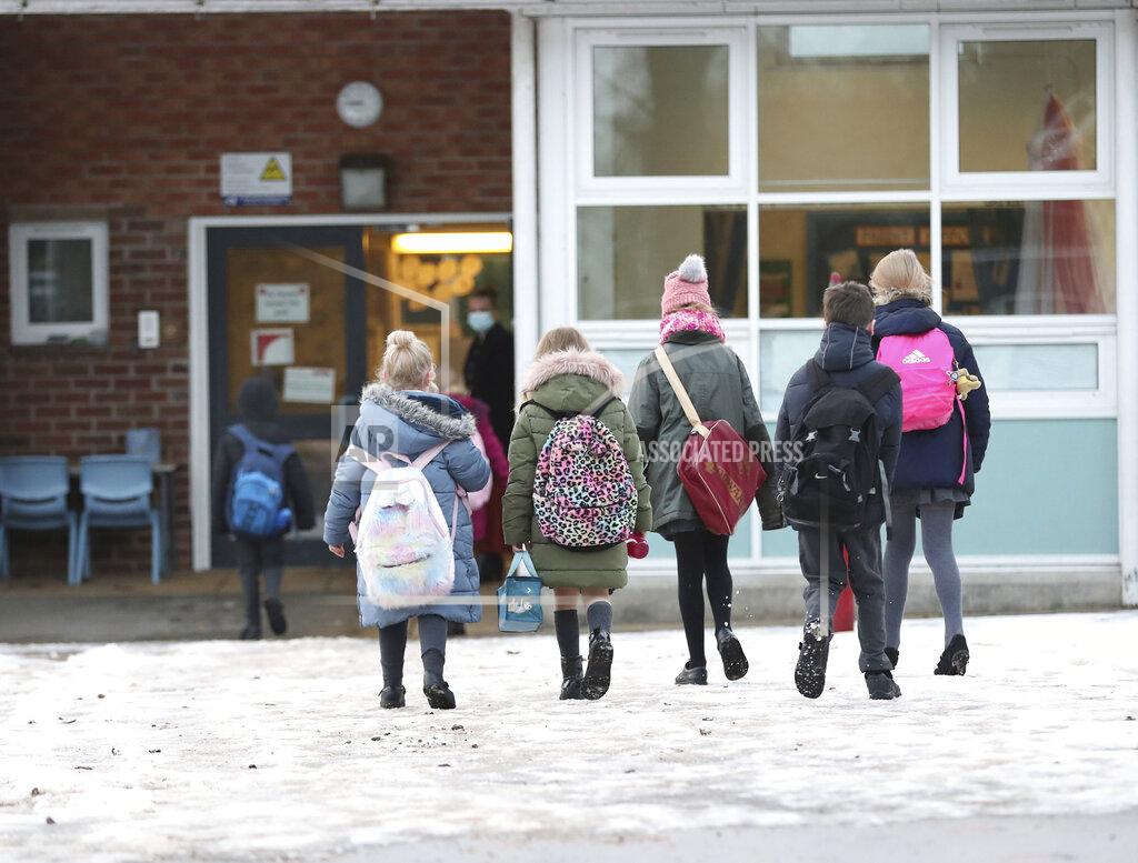 Martin Rickett Pupils arrive at Manor Park School and Nursery in Knutsford, England, as schools across England return after the Christmas break, Monday, Jan. 4, 2021. Britain's Prime Minister Boris Johnson on Sunday insisted he has “no doubt” that schools are safe and urged parents to send their children back into the classroom Monday in areas of England where schools plan to reopen. (Martin Rickett/PA via AP)