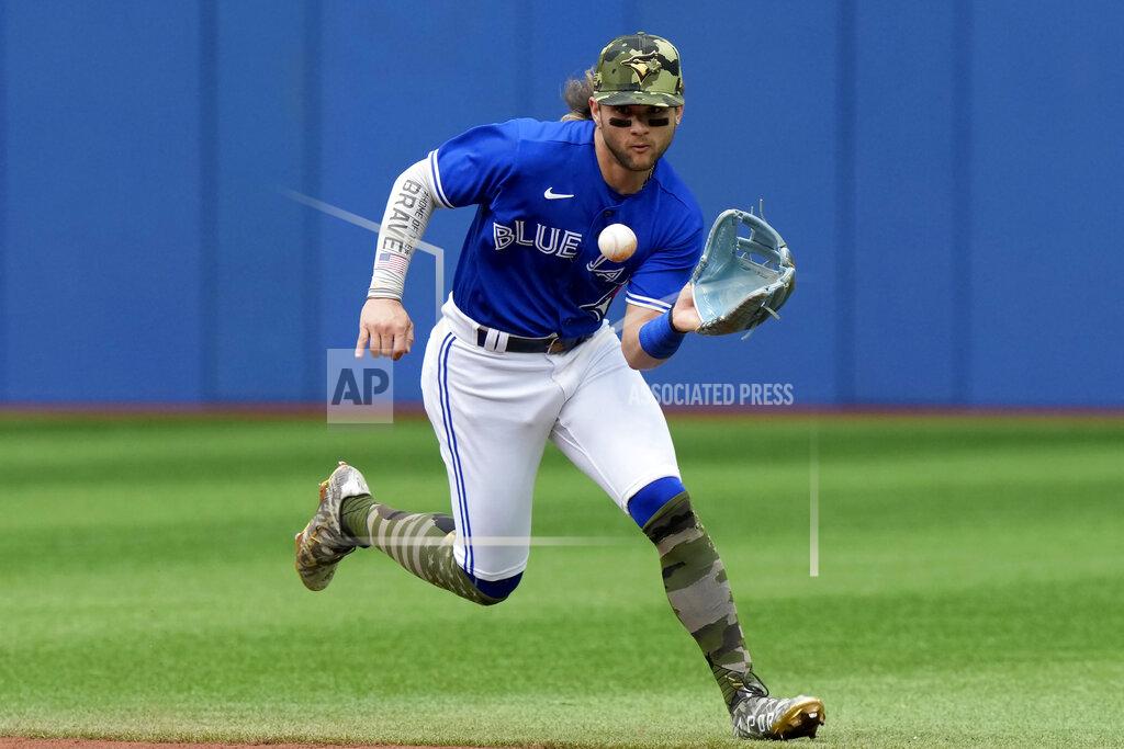 Frank Gunn Toronto Blue Jays shortstop Bo Bichette (11) runs down a ground ball hit by Cincinnati Reds third baseman Mike Moustakas during the fifth inning of a baseball game in Toronto, Saturday, May 21, 2022. (Frank Gunn/The Canadian Press via AP)