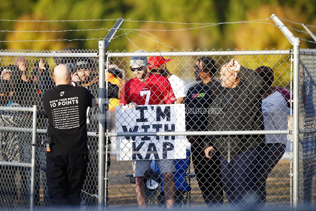 Todd Kirkland Fans watch from behind a fence as free agent quarterback Colin Kaepernick participates in a workout for NFL football scouts and media, Saturday, Nov. 16, 2019, in Riverdale, Ga. (AP Photo/Todd Kirkland)