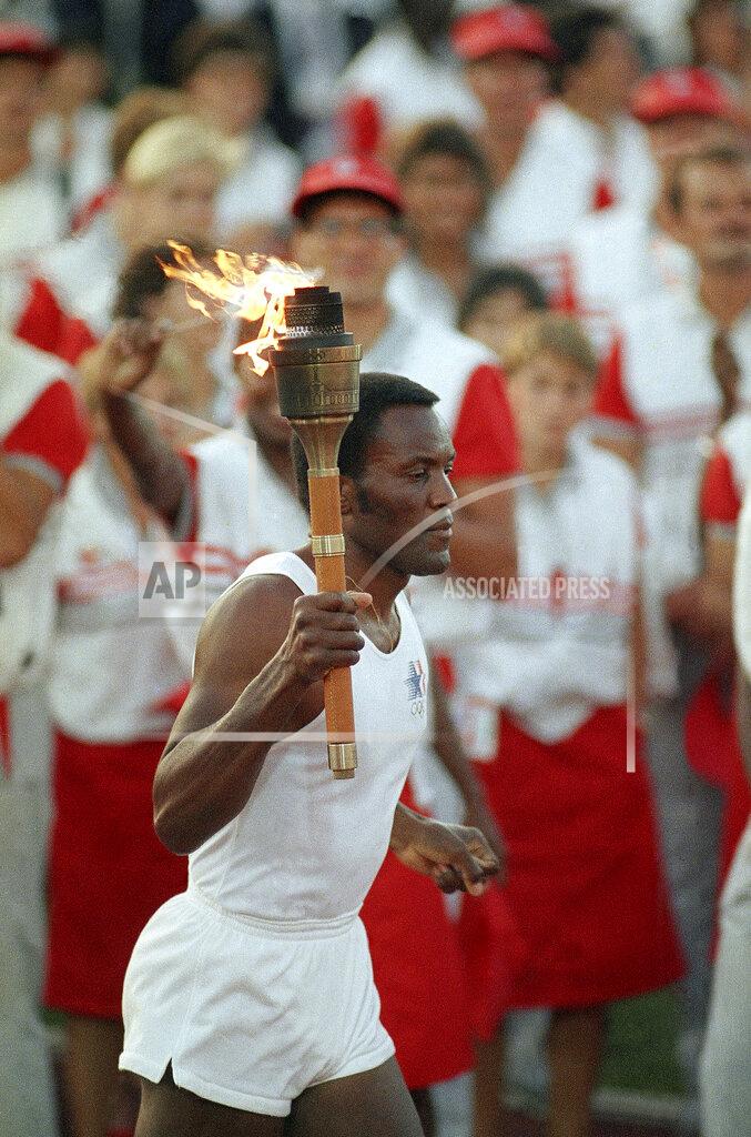 Peter Leabo FILE - In this July 28, 1984, file photo, 1960 U.S. gold medal decathlete Rafer Johnson carries the Olympic torch through the Los Angeles Memorial Coliseum before lighting the Olympic flame and formally launching the 1984 summer games. Rafer Johnson died Wednesday, Dec. 2, 2020. He was 86. He died at his home in the Sherman Oaks section of Los Angeles, according to family friend Michael Roth. (AP Photo/Peter Leabo, File)