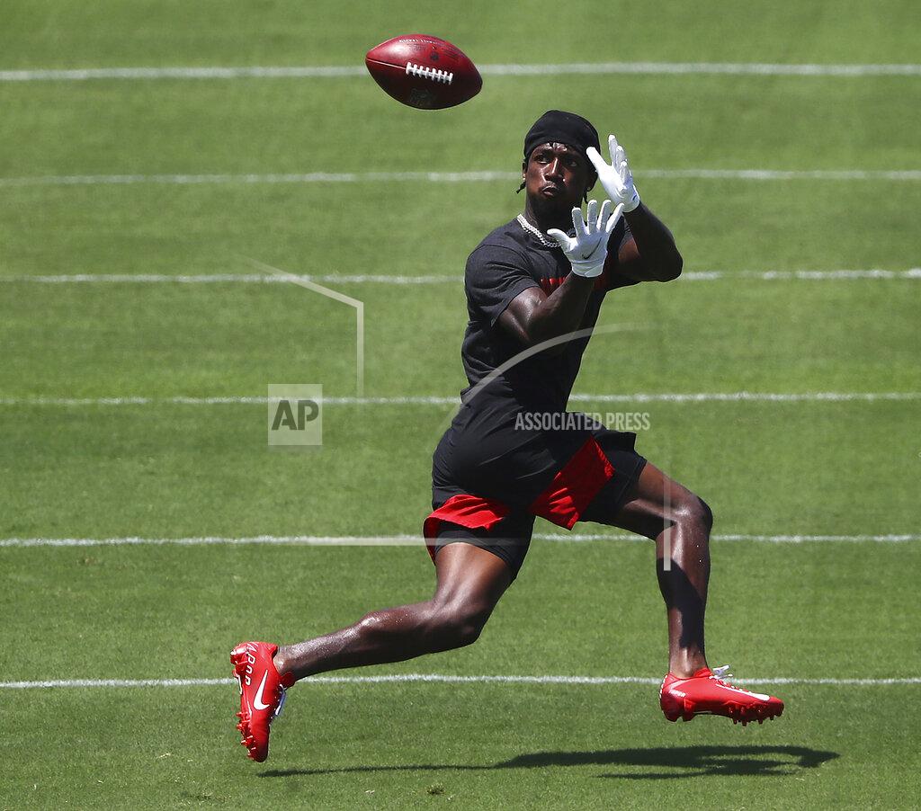 FILE - In this Aug. 4, 2020, file photo, Atlanta Falcons wide receiver Calvin Ridley catches a pass from Matt Ryan during a team strength and conditioning NFL football workout in Flowery Branch, Ga. It would be easy to overlook Calvin Ridley, being a receiver who plays on the same team as Julio Jones. Ridley, though, has other ideas. Heading into his third year with the Atlanta Falcons, he's planning on a breakout season and making sure everybody knows his name, too. (Curtis Compton/Atlanta Journal-Constitution via AP, FIle)