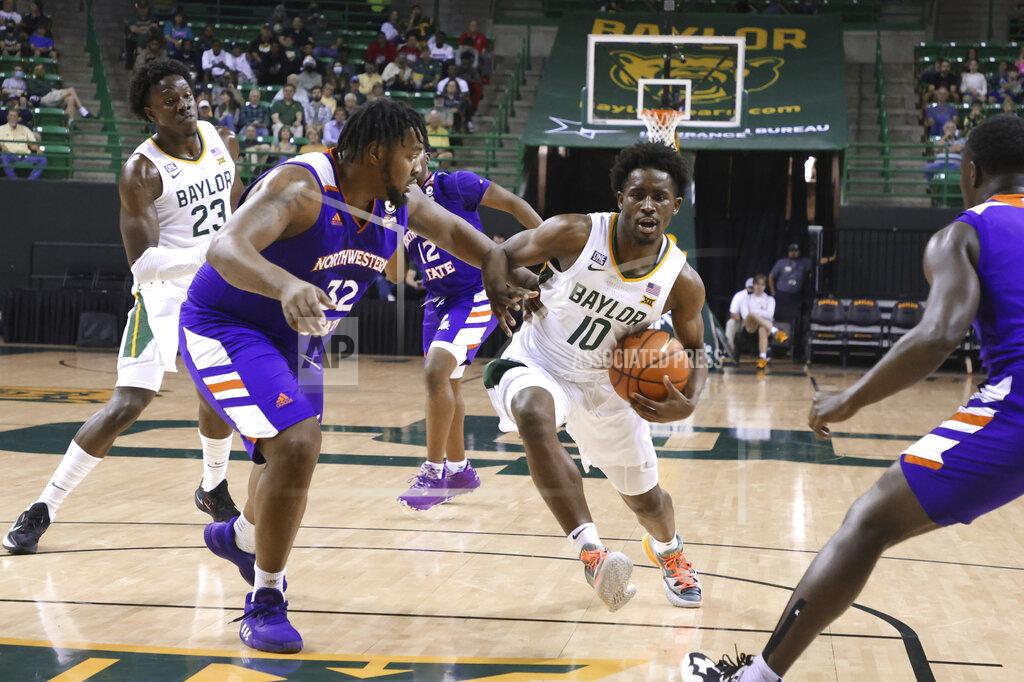 Rod Aydelotte Baylor guard Adam Flagler drives on Northwestern State center Larry Owens, left, during the second half of an NCAA college basketball game Tuesday, Dec. 28, 2021, in Waco, Texas. (AP Photo/Rod Aydelotte)