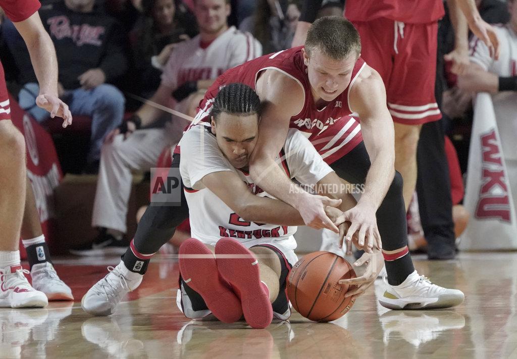 Tim Broekema Western Kentucky guard Dalano Banton (20) tries to take control of the ball against Wisconsin guard Brad Davison (34) during the second half of an NCAA college basketball game, Saturday, Dec. 29, 2018, in Bowling Green, Ky. (AP Photo/Tim Broekema)