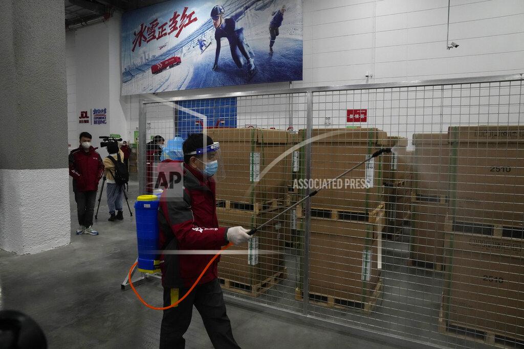Ng Han Guan A worker disinfects the storage area at the Main Distribution Center built to provide logistic support for the upcoming Beijing Winter Olympics and Paralympics in Beijing, China, Thursday, Dec. 9, 2021. The 34-meter-tall building has started operation at the end of last year to receive, store and distribute furniture, sport and technical equipment, and other materials for the current test events and next year's Winter Games. (AP Photo/Ng Han Guan)