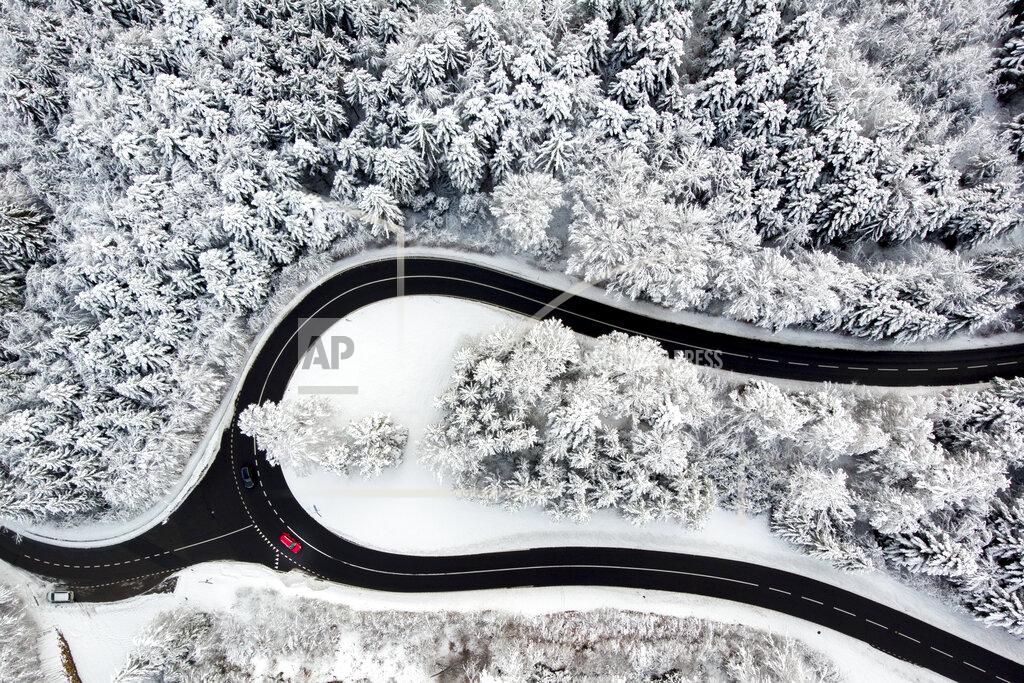 Laurent Gillieron Cars drive on the road of the "Col du Mollendruz" among snow-covered trees in a forest after snowfall, in the Jura Mountains, in Mont-la-Ville, Switzerland, Sunday, Dec. 6, 2020. (Laurent Gillieron/Keystone via AP)