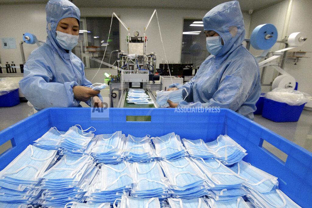 Uncredited Workers wearing face masks to help curb the spread of the coronavirus arrange face masks from a machine at a factory in Handan city in north China's Hebei province on Jan. 8, 2021. China's economy grew 2.3% in 2020 as a recovery from the coronavirus pandemic accelerated while the United States, Europe and Japan struggled with disease flare-ups. (Chinatopix via AP)