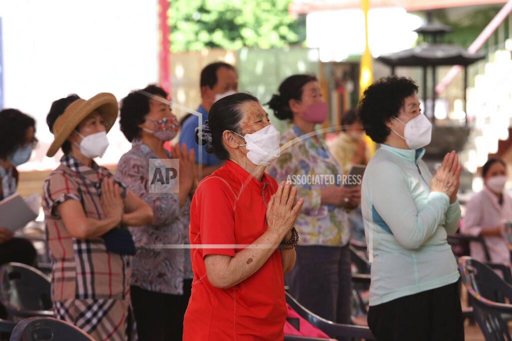 Ahn Young-Joon People wearing face masks to help protect against the spread of the new coronavirus pray during a service at the Chogyesa temple in South Korea, Monday, June 22, 2020. (AP Photo/Ahn Young-joon)