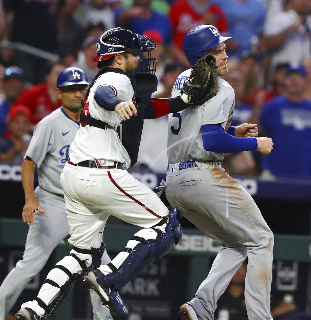 Curtis Compton Atlanta Braves catcher Travis d'Arnaud, front left, tags out Los Angles Dodgers' Freddie Freeman, right, in a rundown between third and home on a fielder's choice during the sixth inning of a baseball game Sunday, June 26, 2022, in Atlanta. (Curtis Compton/Atlanta Journal-Constitution via AP)