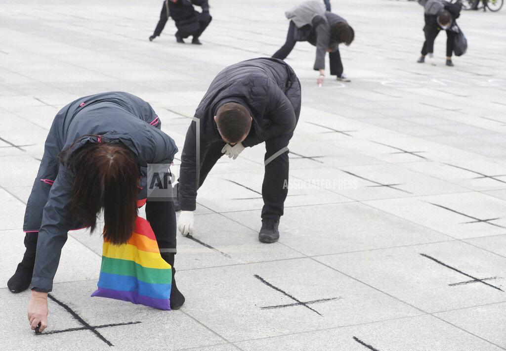 Czarek Sokolowski People paint black crosses for the victims of the COVID-19 pandemic in Pilsudski Square, Warsaw, Poland, Saturday, April 10, 2021. Almost 56,000 people have died of COVID-19 in this nation of around 38 million. (AP Photo/Czarek Sokolowski)