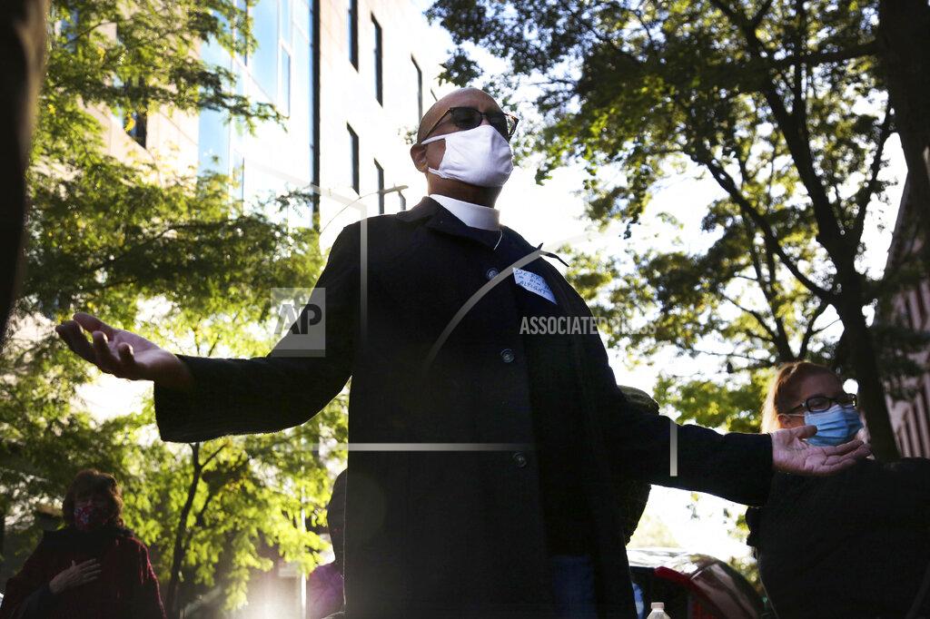 Jessie Wardarski Pastor Derrick McQueen of St. James Presbyterian Church in Harlem, lifts his hands and closes his eyes in prayer during an interfaith gathering outside of the Judson Memorial Church near Washington Square Park in New York, Wednesday, Nov. 4, 2020. Muslims, Jews, Christians and Buddhists came together to show solidarity among faith communities as the country awaits the final result of the U.S. presidential election. (AP Photo/Jessie Wardarski)