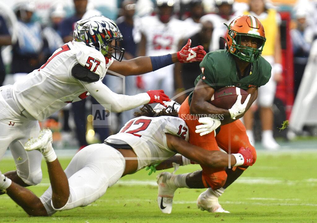 Jim Rassol Florida A&M running back Bishop Bonnett (1) is tackled for a loss by Jackson State defensive back Cam'Ron Silmon (12) and linebacker Nyles Gaddy (57) in the second quarter of an NCAA college football game, Sunday, Sept. 5, 2021, in Miami Gardens, Fla. (AP Photo/Jim Rassol)