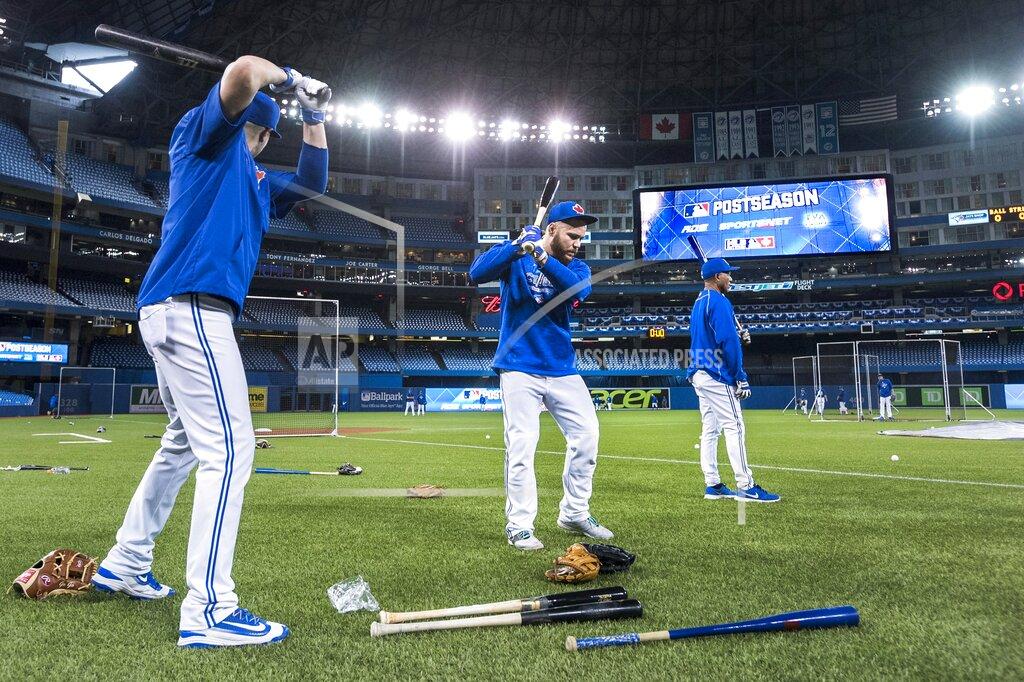 FILE - In this Oct. 7, 2015, file photo, Toronto Blue Jays Russell Martin, center, and Troy Tulowitzki, left, prepare to take batting practice during a team workout at the Rogers Centre in Toronto. All 30 Major League Baseball teams will train at their regular-season ballparks for the pandemic-shortened season after the Blue Jays received a Canadian federal government exemption on Thursday, July 2, 2020, to work out at Rogers Centre. Toronto will move camp from its spring training complex in Dunedin, Fla., where players reported for intake testing. The Blue Jays will create a quarantine environment at Rogers Centre and the adjoining Toronto Marriott City Centre Hotel which overlooks the field. (Darren Calabrese/The Canadian Press via AP, File)