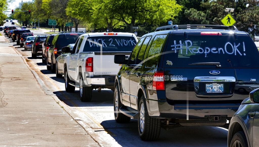 Chris Landsberger Cars line the north and south bound lanes of Lincoln Blvd. during the Let's Get Oklahoma Open For Business rally at the Oklahoma State Capitol in Oklahoma City, Okla. on Wednesday, April 15, 2020. Participants drove their cars around the Capitol to protest the hardship Oklahoma citizens are being placed in due to businesses being forced to close during the COVID-19 pandemic. (Chris Landsberger/The Oklahoman via AP)
