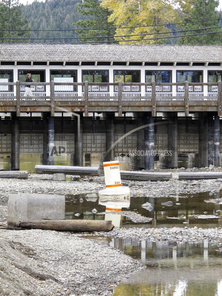 Scott Sonner Water flows have slowed to a trickle through the dam at Lake Tahoe at the mouth of the Truckee River in Wednesday, Oct. 20, 2021 at Tahoe City, Calif.. Drought fueled by climate change has dropped Lake Tahoe below its natural rim and halted flows into the Truckee River, an historically cyclical event that's occurring sooner and more often than it used to raising fears about what might be in store for the famed alpine lake. (AP Photo/Scott Sonner).