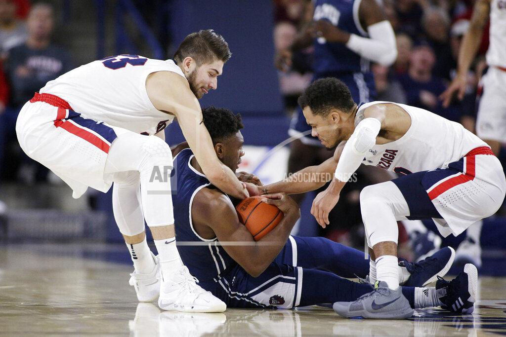 Young Kwak Gonzaga forward Killian Tillie, left, and guard Geno Crandall, right, tie up Loyola Marymount guard James Batemon during the first half of an NCAA college basketball game in Spokane, Wash., Thursday, Jan. 17, 2019. (AP Photo/Young Kwak)