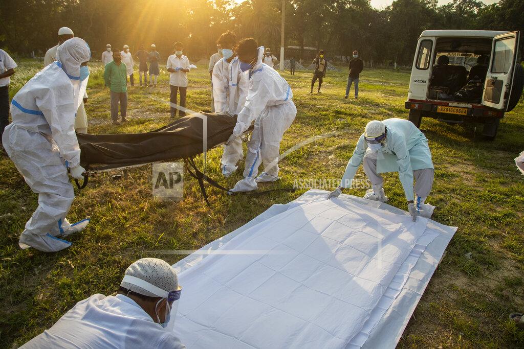 Anupam Nath FILE - In this April 25, 2021, file photo, municipal workers prepare to bury a person who died of COVID-19 in Gauhati, India. Despite clear signs that India was being swamped by another surge of coronavirus infections, Prime Minister Narendra Modi refused to cancel campaign rallies, a major Hindu festival and cricket matches with spectators. The crisis has badly dented Modi’s carefully cultivated image as an able technocrat. (AP Photo/Anupam Nath, File)