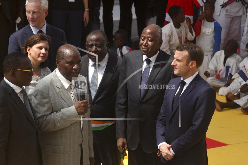 Ivory Coast's Prime Minister Amadou Gon Coulibaly, center-right, stands next to France's President Emmanuel Macron, right, during the French President's visit to the country, in the Koumassi suburb of Abidjan, Ivory Coast Saturday, Dec. 21, 2019. Ivory Coast's Prime Minister Amadou Gon Coulibaly, the presidential candidate of Ivory Coast's ruling party, died Wednesday, July 8, 2020 just days after returning from two months of medical treatment in France, where he previously had undergone a heart transplant, the country's presidency announced. (AP Photo/Diomande Ble Blonde)