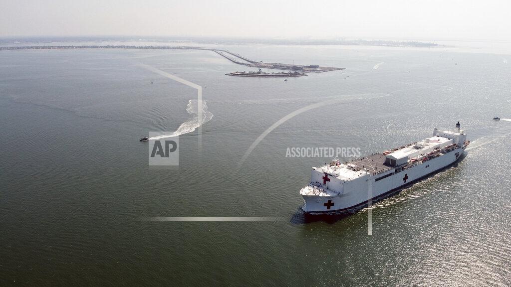 In this photo provided by the U.S. Navy, the Military Sealift Command hospital ship USNS Comfort (T-AH 20) departs Naval Station Norfolk, Va., March 28, 2020. Comfort is deploying in support of the nation's COVID-19 response efforts and will serve as a referral hospital for non-COVID-19 patients currently admitted to shore-based hospitals. This allows shore-based hospitals to focus their efforts on COVID-19 cases. (Petty Officer 1st Class Joshua Sheppard/U.S. Navy via AP)