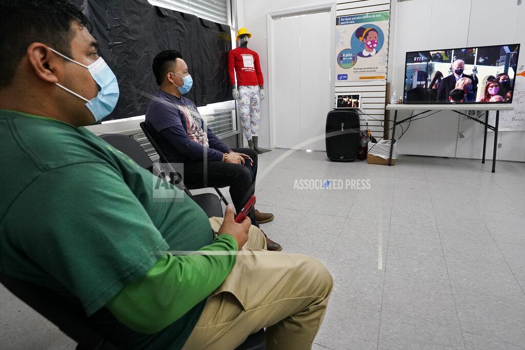 Kathy Willens Workers Justice Project Director Gonzalo Cruz, left, and organizer Juan Carlos Romero watch President Joe Biden's presidential inauguration on TV from the Workers Justice Center, Wednesday, Jan. 20, 2021, in the Sunset Park neighborhood of Brooklyn in New York. The Workers Justice Project is a Brooklyn based non-profit that helps immigrants. (AP Photo/Kathy Willens)