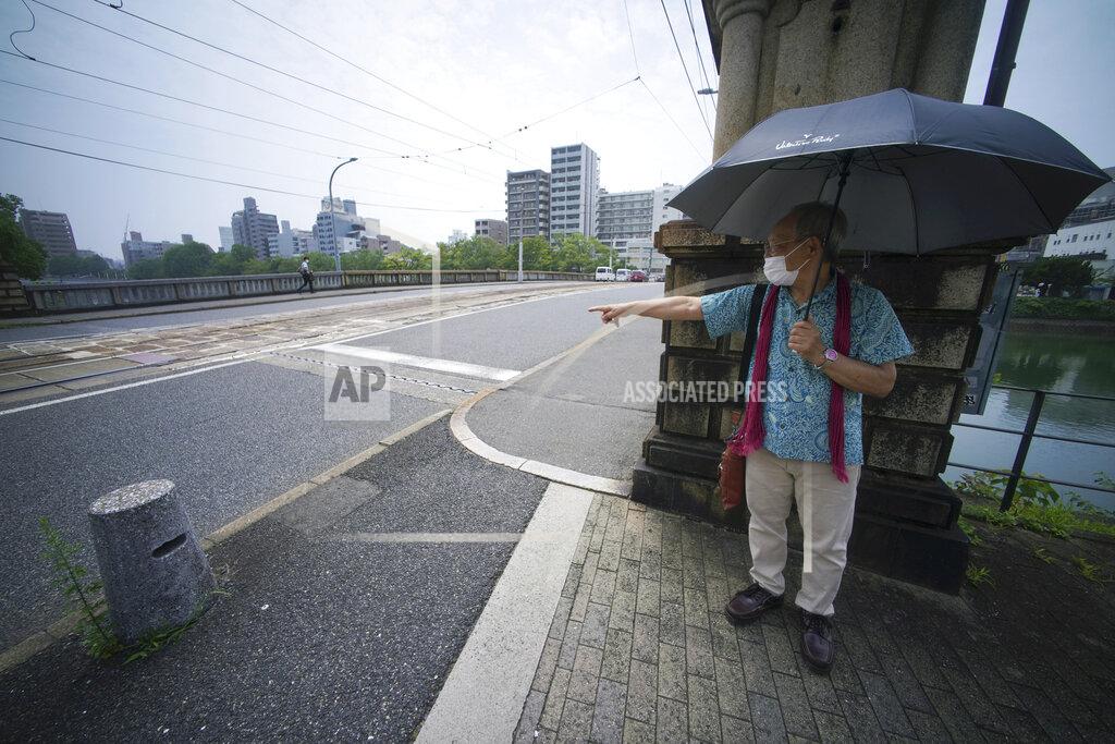 Eugene Hoshiko Lee Jong-keun shows his position at Kojin Bridge at the moment an atomic bomb exploded in Hiroshima, western Japan, Tuesday, Aug. 4, 2020. For nearly 70 years, until he turned 85, Lee hid his past as an atomic bomb survivor, fearful of the widespread discrimination against blast victims that has long persisted in Japan. But Lee, 92, is now part of a fast-dwindling group of survivors, known as hibakusha, that feels a growing urgency - desperation even - to tell their stories. (AP Photo/Eugene Hoshiko)