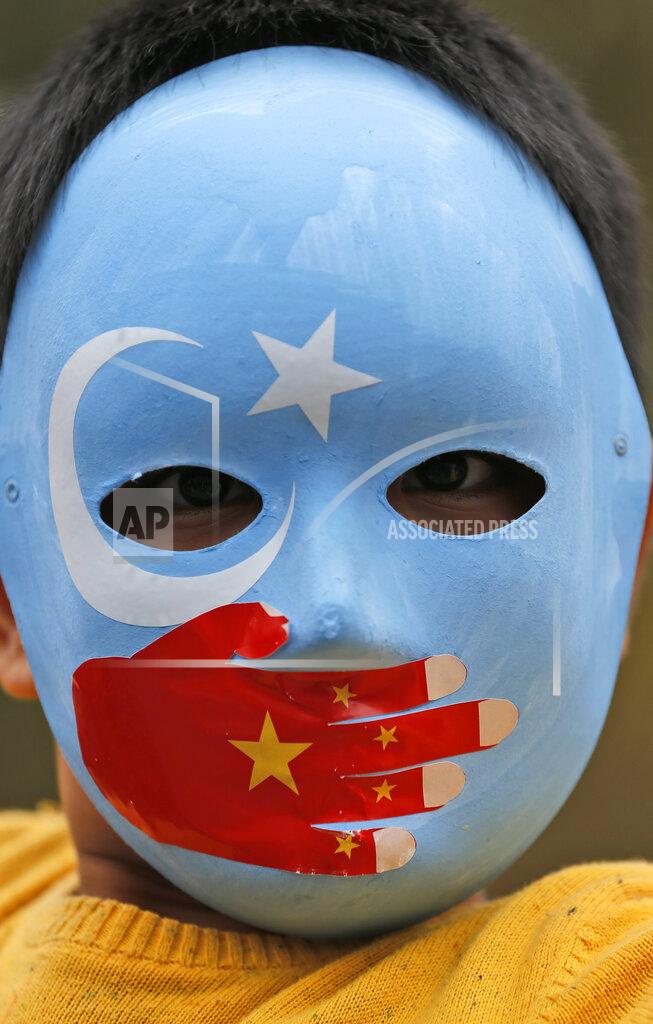 Lefteris Pitarakis FILE - In this Tuesday, Nov. 6, 2018, file photo, a child from the Uighur community living in Turkey wears a mask in the colors of the flag ethnic Uighurs call 'East Turkestan', with a painted hand with the colours of China's flag, during a protest in Istanbul, against what they allege is oppression by the Chinese government to Muslim Uighurs in the far-western Xinjiang province. Because of shared cultural ties, Turkey has long been a safe haven for the Uighurs, a Turkic group native to Xinjiang. Opposition legislators in Turkey are accusing Ankara's leaders of secretly selling out Uighurs to China in exchange for coronavirus vaccines. (AP Photo/Lefteris Pitarakis, File) members of the Uighur community living in Turkey carry flags of what ethnic Uighurs call 'East Turkestan', during a protest in Istanbul, against what they allege is oppression by the Chinese government to Muslim Uighurs in far-western Xinjiang province. Because of shared cultural ties, Turkey has long been a safe haven for the Uighurs, a Turkic group native to China's far west Xinjiang region. Opposition legislators in Turkey are accusing Ankara's leaders of secretly selling out Uighurs to China in exchange for coronavirus vaccines. (AP Photo/Lefteris Pitarakis, File)