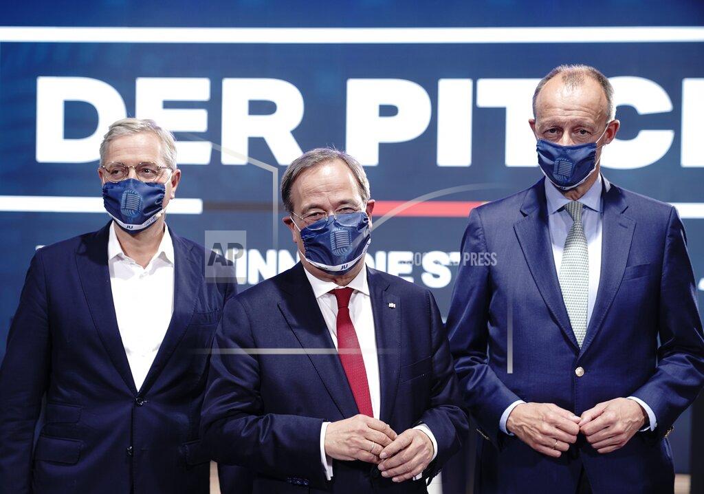 Michael Kappeler File - In this Saturday, Oct. 17, 2020 file photo the three candidates for the chairmanship of the Christian Democratic Union party, CDU, Norbert Roettgen, left, Armin Laschet, center, and Friedrich Merz, right, attends an event of the party's youth organisation, Junge Union (JU) in Berlin. German Chancellor Angela Merkel's center-right party is choosing a new leader on the weekend Saturday Jan. 16 and Sunday Jan. 17, 2021, a decision that will help determine who succeeds Merkel at the helm of the European Union's biggest economy after a 16-year reign. (Michael Kappeler/dpa via AP, file)