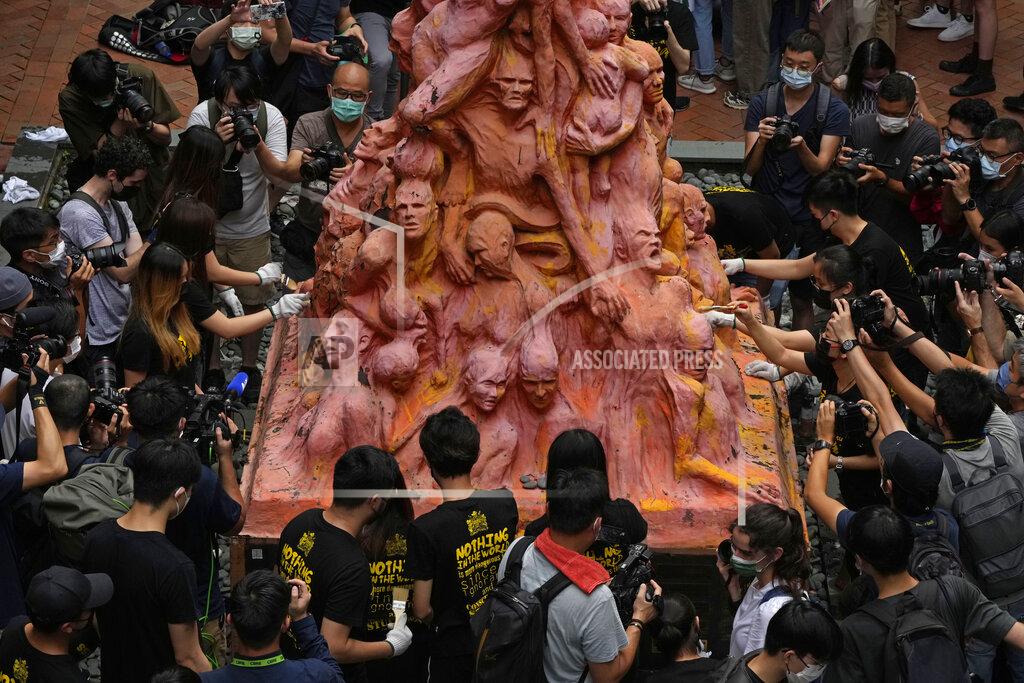 Kin Cheung University students clean the "Pillar of Shame" statue, a memorial for those killed in the 1989 Tiananmen crackdown, at the University of Hong Kong, Friday, June 4, 2021. Police arrested an organizer of Hong Kong's annual candlelight vigil remembering the deadly Tiananmen Square crackdown and warned people not to attend the banned event Friday as authorities mute China's last pro-democracy voices. (AP Photo/Kin Cheung)
