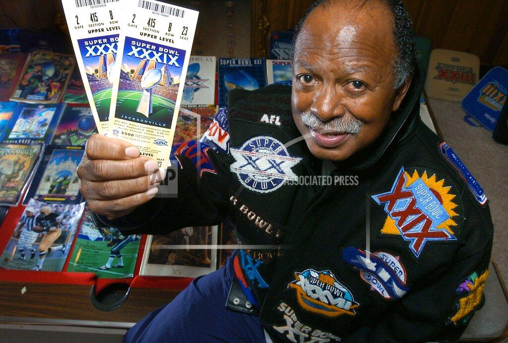 FILE — Gregory Eaton shows his tickets for the 2005 Super Bowl while seated among many other Super Bowl programs and souvenirs, Jan. 31, 2005, in Lansing, Mich. Eaton, along with Tom Henschel, and Don Crisman, have attended every Super Bowl since the first AFL-NFL World Championship held 55 years ago. The three men are meeting at the Super Bowl once again for this year's game, but future meetings are in question. (Vicki Dozier/Lansing State Journal via AP, File)