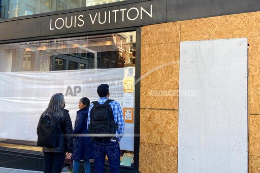 FILE - Union Square visitors look at damage to the Louis Vuitton store on Nov. 21, 2021, after looters ransacked businesses in San Francisco. Groups of thieves, some carrying crowbars and hammers, smashed glass cases and window displays, ransacking high-end stores throughout the San Francisco Bay Area, stealing jewelry, sunglasses, suitcases and other merchandise before fleeing in waiting cars during a weekend of brazen organized theft that shocked holiday shoppers and prompted concerns about the busy retail season. (Danielle Echeverria/San Francisco Chronicle via AP, File)
