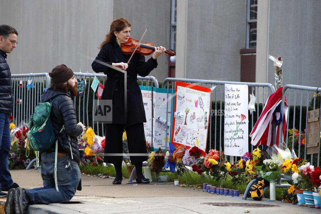 Gene J. Puskar FILE - In this Sunday, Oct. 27, 2019 file photo, Monique Mead plays her violin on the sidewalk outside the Tree of Life synagogue in Pittsburgh on the first anniversary of the shooting at the synagogue, that killed 11 worshippers. (AP Photo/Gene J. Puskar)