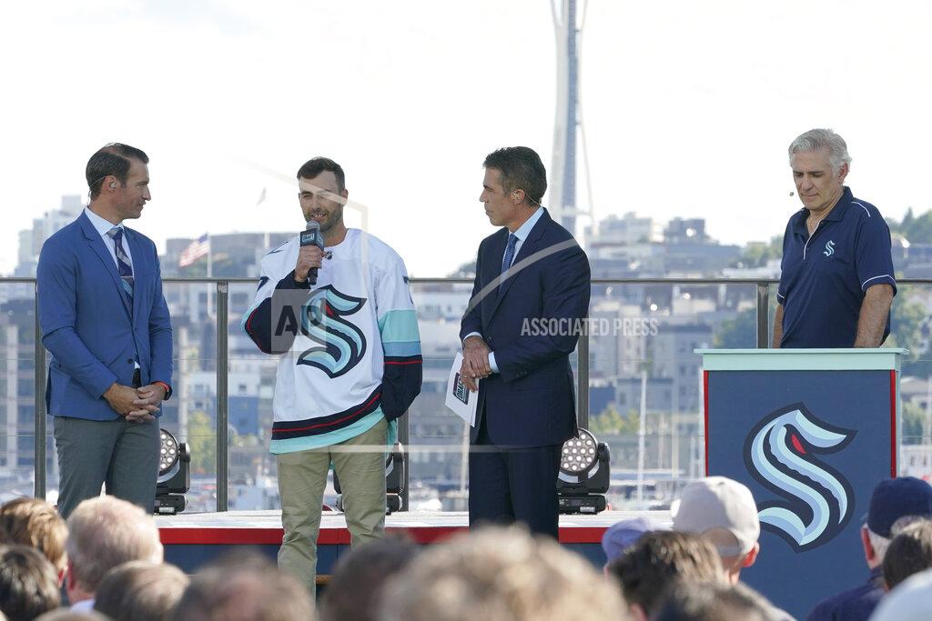 Ted S. Warren Jordan Eberle, second from left, a forward from the New York Islanders, is introduced as a new player for the Seattle Kraken as he stands with ESPN NHL hockey draft hosts Dominic Moore, left, and Chris Fowler, second from right, Wednesday, July 21, 2021, as Kraken general manager Ron Francis, right, listens during the Kraken's NHL hockey expansion draft event in Seattle. (AP Photo/Ted S. Warren)