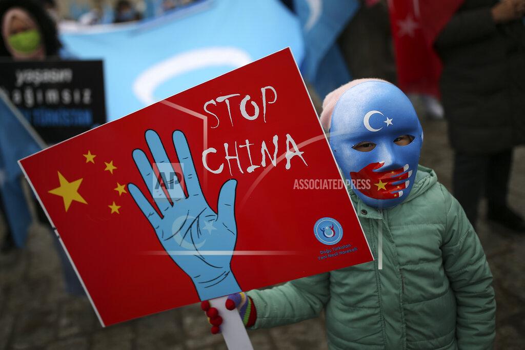 Emrah Gurel A protester from the Uyghur community living in Turkey, holds an anti-China placard during a protest in Istanbul, Thursday, March 25, against against the visit of China's FM Wang Yi to Turkey. Hundreds of Uyghurs staged protests in Istanbul and the capital Ankara, denouncing Wang Yi's visit to Turkey and demanding that the Turkish government take a stronger stance against human rights abuses in China's far-western Xinjiang region. (AP Photo/Emrah Gurel)