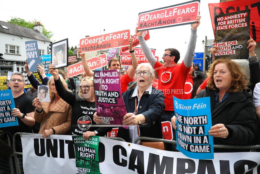 Peter Morrison Demonstrators hold up signs including in Irish reading "Red with Anger, Act now", as they protest outside Hillsborough Castle, ahead of a visit by British Prime Minister Boris Johnson, in Hillsborough, Northern Ireland, Monday, May, 16, 2022. Johnson on Monday renewed British threats to break a Brexit agreement with the European Union, blaming it for a political crisis that's blocking the formation of a new government in Northern Ireland. (AP Photo/Peter Morrison)