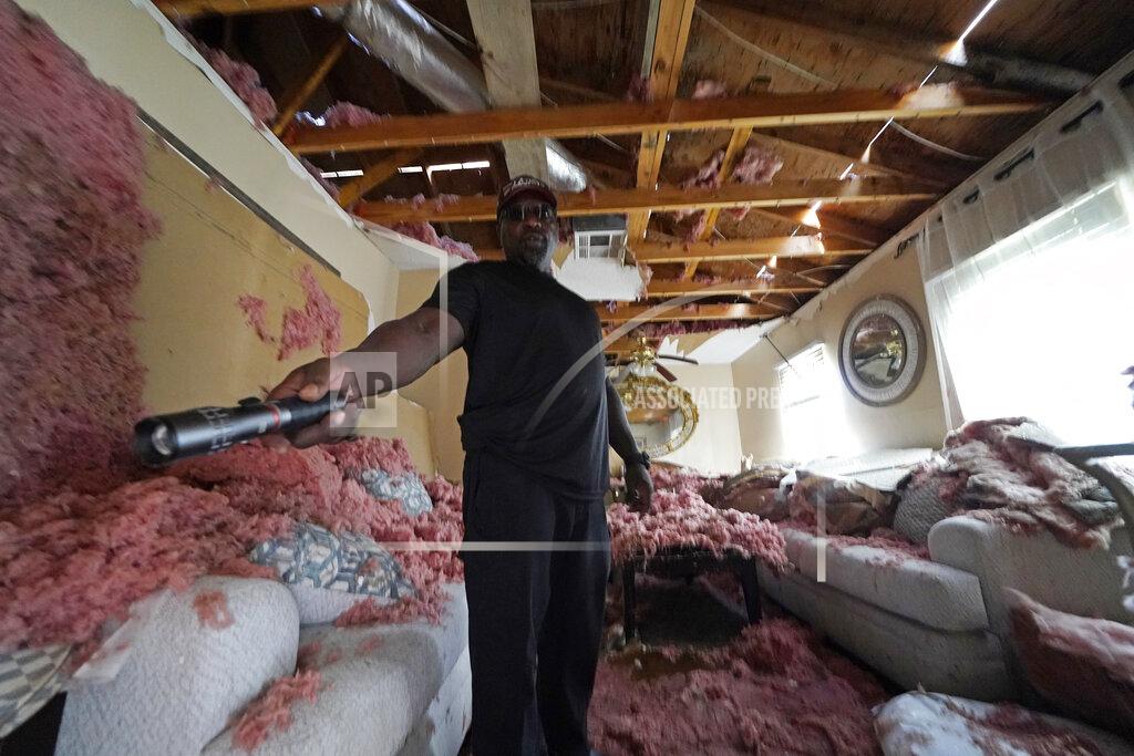 Gerald Herbert Michael Lathers shows the insulation and collapsed ceiling in his flooded home, in the aftermath of Hurricane Ida in LaPlace, La., Tuesday, Sept. 7, 2021. (AP Photo/Gerald Herbert)