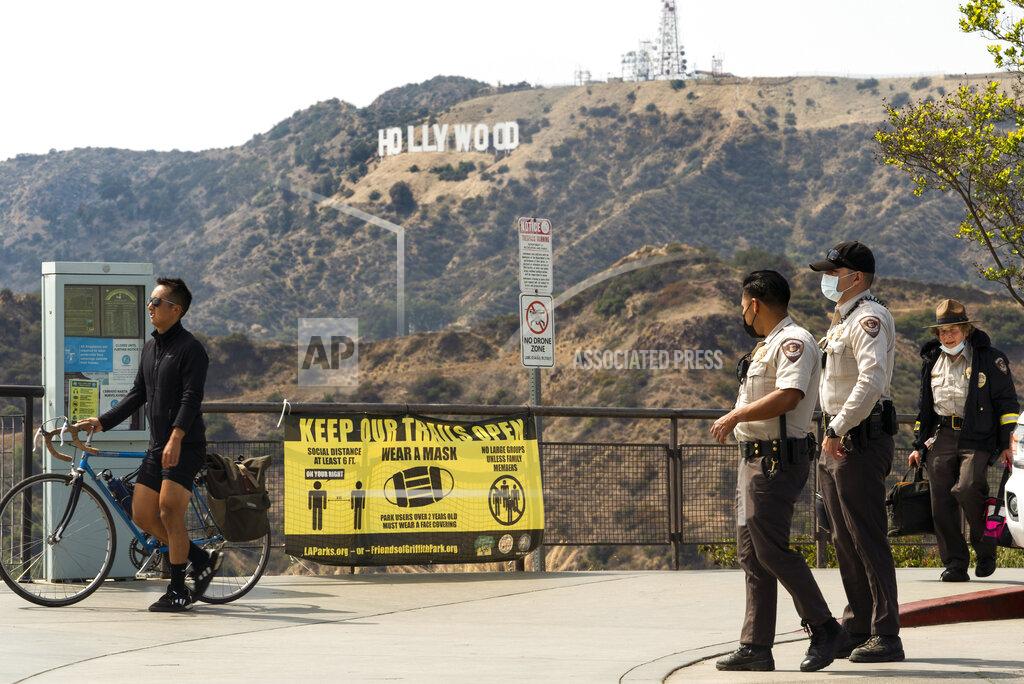 Damian Dovarganes Los Angeles Park Rangers wears facemasks at the the Griffith Observatory in Los Angeles Monday, May. 17, 2021. California is keeping its rules for wearing facemasks in place until the state more broadly lifts its pandemic restrictions on June 15. State officials said Monday, that the delay will give people time to prepare, and for the state to make sure that virus cases stay low. (AP Photo/Damian Dovarganes)