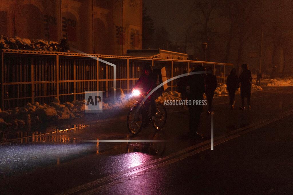 Evgeniy Maloletka A man rides by bicycle at the city center which lost electrical power after yesterday's Russian rocket attack in Kyiv, Ukraine, Thursday, Nov. 24, 2022. (AP Photo/Evgeniy Maloletka)