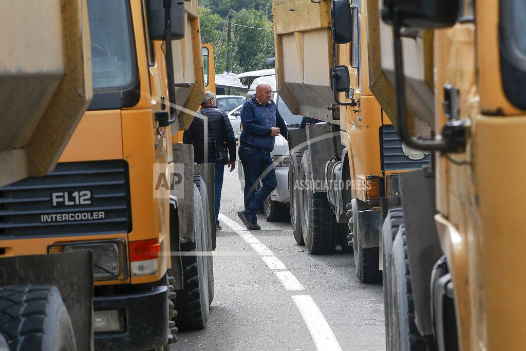 Visar Kryeziu Local Serbs stand beside a road blocking the road leading to the northern Kosovo border crossing of Jarinje, Tuesday, Sept. 21, 2021. Tensions soared Monday when Kosovo special police with armored vehicles were sent to the border to impose a rule on temporarily replacing Serb license plates from cars while they drive in Kosovo. (AP Photo/Visar Kryeziu)