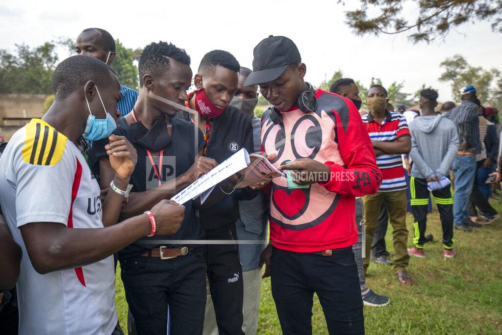 Jerome Delay Young Ugandans check the voters listings as they wait to vote in Kampala, Uganda, Thursday, Jan. 14, 2021. Ugandans are voting in a presidential election tainted by widespread violence that some fear could escalate as security forces try to stop supporters of leading opposition challenger BobiWine from monitoring polling stations.(AP Photo/Jerome Delay)
