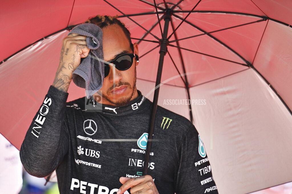 Mercedes driver Lewis Hamilton of Britain holds an umbrella prior to the start of the Azerbaijan Formula One Grand Prix at the Baku circuit, in Baku, Azerbaijan, Sunday, June 12, 2022. (Hamad Mohammed, Pool Via AP)