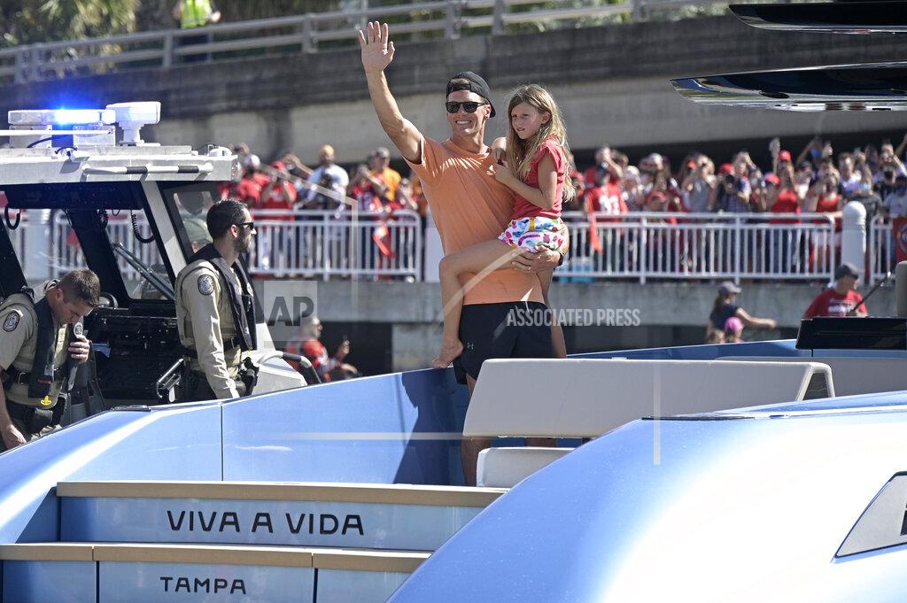 Tampa Bay Buccaneers quarterback Tom Brady holds his daughter Vivian Lake while waving to fans during a celebration of their Super Bowl 55 victory over the Kansas City Chiefs with a boat parade, Wednesday, Feb. 10, 2021, in Tampa, Fla. (AP Photo/Phelan M. Ebenhack)