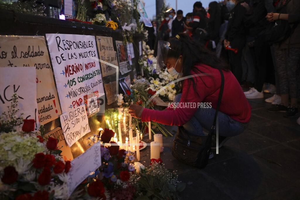Rodrigo Abd A woman lights candles on a memorial for the victims of the recent protests, outside the Congress building, as they wait for news from inside on who will be the country's next president, in Lima, Peru, Sunday, Nov. 15, 2020. Interim President Manuel Merino resigned following massive protests unleashed when lawmakers ousted President Martin Vizcarra. (AP Photo/Rodrigo Abd)