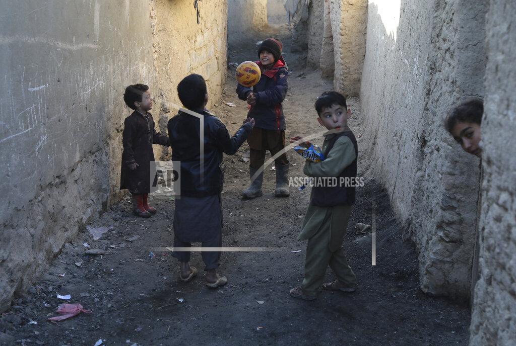 Rahmat Gul Internally displaced boys play with a ball outside their temporary home in the city of Kabul, Afghanistan, Wednesday, Dec. 30, 2020. Save the Children has warned that more than 300,000 Afghan children face freezing winter conditions that could lead to illness, in the worst cases death, without proper winter clothing and heating. (AP Photo/Rahmat Gul)