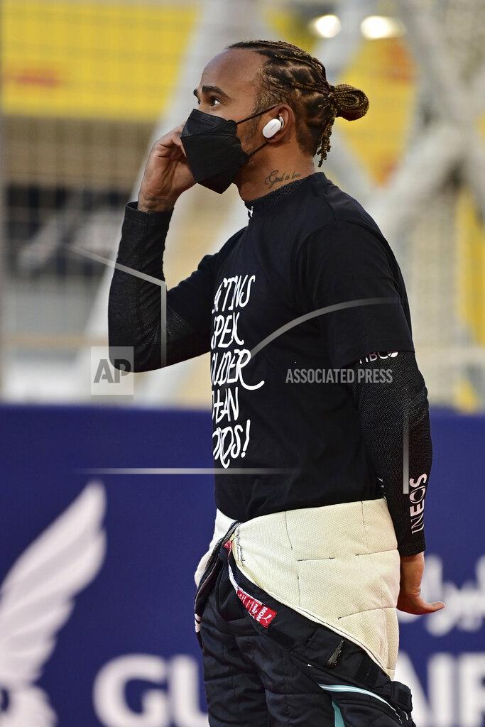 Andrej Isakovic Mercedes driver Lewis Hamilton of Britain speaks on his mobile phone at the starting grid prior to the start of the Bahrain Formula One Grand Prix at the Bahrain International Circuit in Sakhir, Bahrain, Sunday, March 28, 2021. (Andrej Isakovic, Pool via AP)